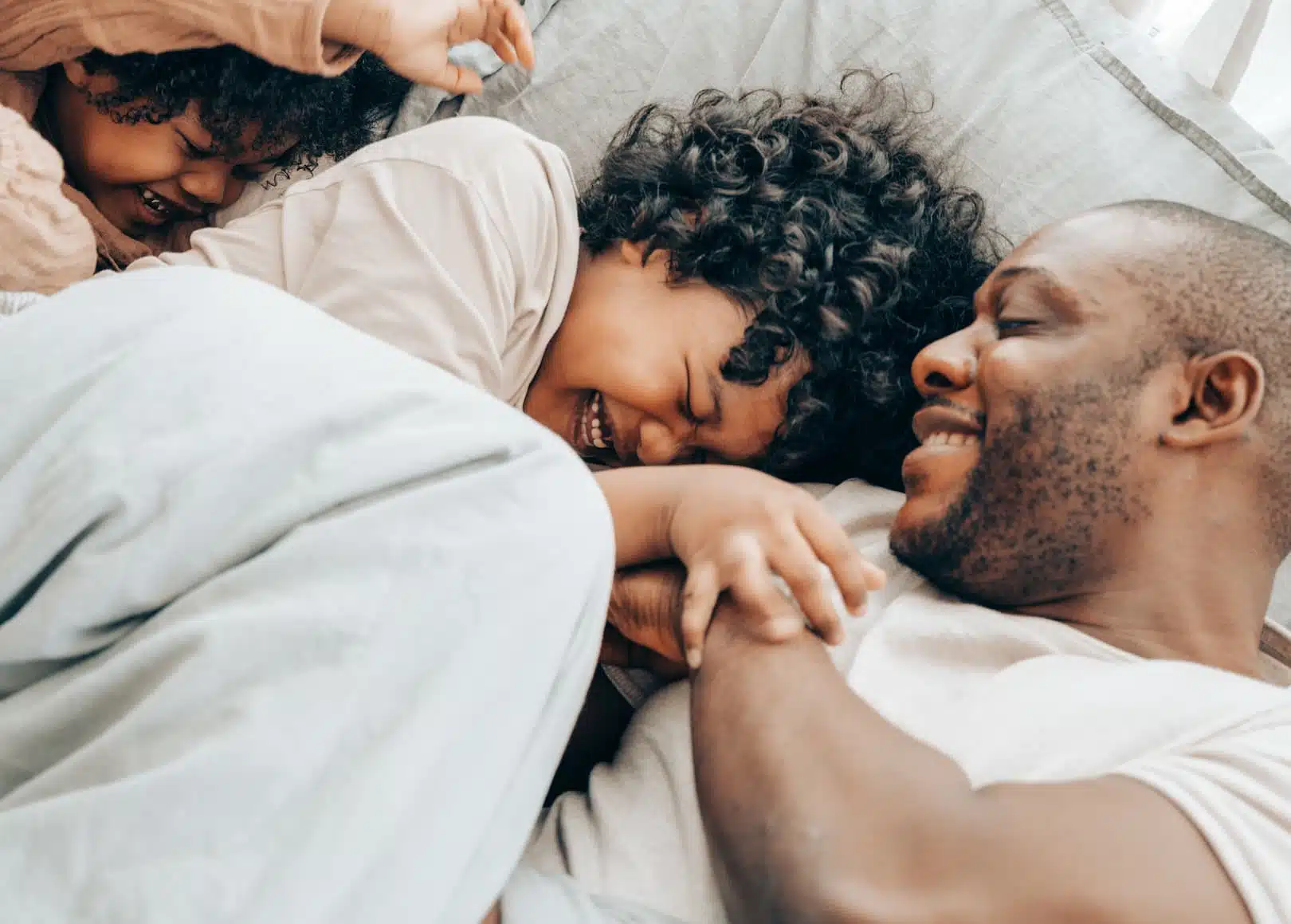 Famille dans un lit en train de jouer